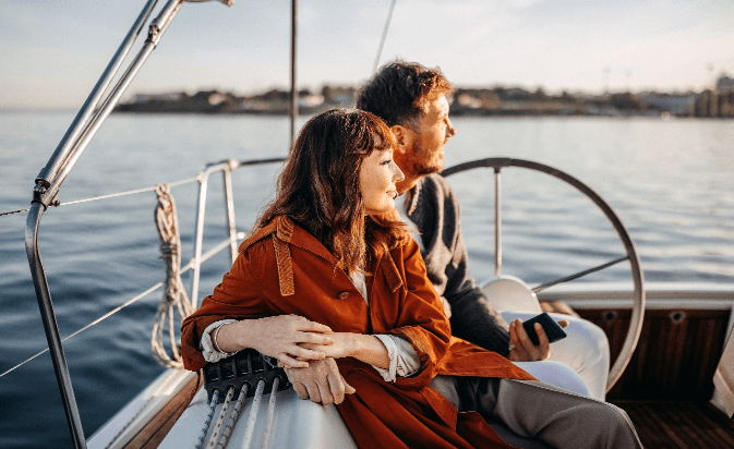 A couple on a sailboat looking at the ocean.