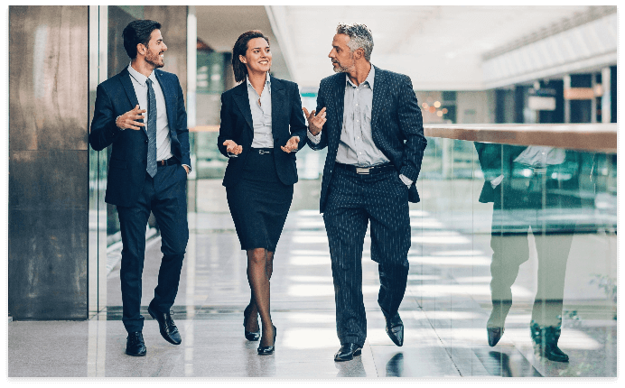 Three business people walking in an office building.